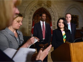 Minister of Democratic Institutions Maryam Monsef, flanked by fellow MPs Mark Holland, right, and Greg Fergus, speaks to reporters Thursday about electoral reform.