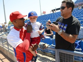 Michel Lopez, right, asks Yosvani Alarcon from the Cuban national team if he would pose for a photo with his son, Maximus, 2, before a game between the Ottawa Champions against Cuban national team at RCGT Park on Father's Day, June 19, 2016.