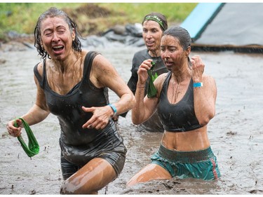 Milene Lécuyer (R) has a shocked look as she climbs out of a mud pit as the Mud Hero Ottawa 2016 continued on Sunday at Commando Paintball located east of Ottawa.