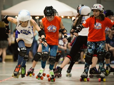 Montreal Rhythm and Bruise jammer Louise Rouan-Leroux, left, leaps past Ottawa Junior Roller Derby's Kaitlin Golab, while Kaitlin Caron, right, looks on.