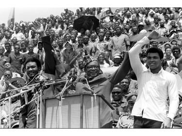 FILE - This is a  Sept. 22, 1974 file photo of Zaire's President Mobutu Sese Seko, center, as he raises the arms of heavyweight champ George Foreman, left, and Muhammad Ali, right, in Kinshasa,  Zaire. It was 40 years ago that two men met just before dawn on Oct. 30, 1974, to earn $5 million in the Rumble in the Jungle. In one of boxing's most memorable moments, Muhammad Ali stopped the fearsome George Foreman to recapture the heavyweight title in the impoverished African nation of Zaire.