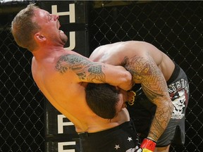 Jon Charbonneau, left, holds opponent Corey Knapp in a standing guillotine hold during the King of the Cage mixed martial arts event at Rexall Place in Edmonton Saturday, July 18, 2009.