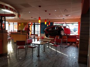 The front of a car sits inside a Popeyes restaurant in Ottawa on Saturday, June 25, 2016.
