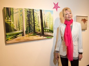 Ottawa Art Gallery director Alexandra Badzak beside some of the art, including a piece by Erin Robertson (R) and Gavin Lynch (L), that is up for auction as part of the gallery's fundraising event on Thursday, June 9.