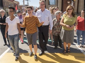 Somerset Coun. Catherine McKenney, second from left, and Mayor Jim Watson, center, help officially open the permanent rainbow crosswalks at the intersection of Somerset and Bank Streets Thursday.