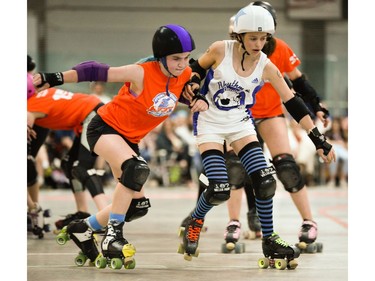 Ottawa Junior Roller Derby's Julianna Haugen, left, battles for position.