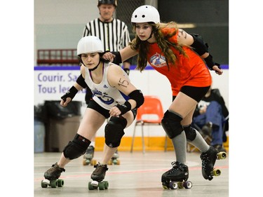 Ottawa Junior Roller Derby's Sarah Gibson, 3, tries to push Montreal Rhythm and Bruise jammer Anne Chaput-De Angelis, 15, out of the ring.