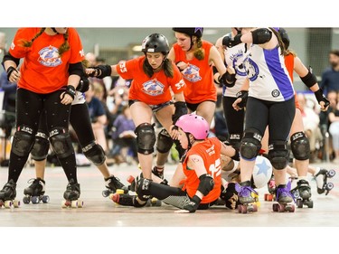 Ottawa Junior Roller Derby's Skye Ferguson, 15, hits the deck as teammate Finley Briggs-Webb, 333, looks to stay on her wheels.