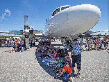 Patrons seek shelter from the sun under a plane.