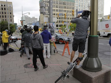 Pedestrians and news crews were clamouring into the early evening to catch glimpses of the sinkhole that opened up this morning just east of the intersection of Rideau Street and Sussex Drive, which caused a gas leak and building evacuations, on June 8, 2016. Cement trucks were just beginning to fill the hole around 6 p.m.