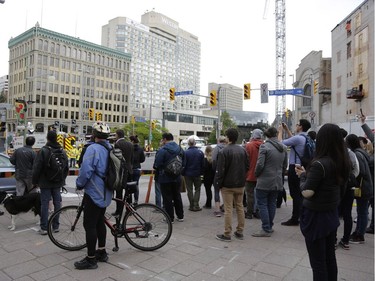 Pedestrians and news crews were clamouring into the early evening to catch glimpses of the sinkhole that opened up this morning just east of the intersection of Rideau Street and Sussex Drive, which caused a gas leak and building evacuations, on June 8, 2016. Cement trucks were just beginning to fill the hole around 6 p.m.