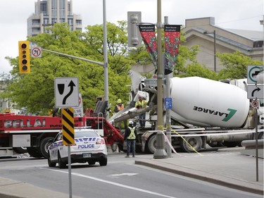 Pedestrians and news crews were clamouring into the early evening to catch glimpses of the sinkhole that opened up this morning just east of the intersection of Rideau Street and Sussex Drive, which caused a gas leak and building evacuations, on June 8, 2016. Cement trucks were just beginning to fill the hole around 6 p.m. (David Kawai)