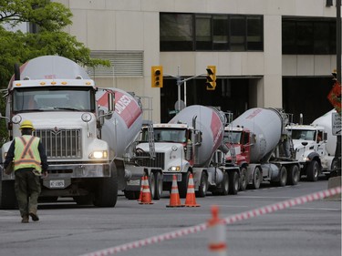 Pedestrians and news crews were clamouring into the early evening to catch glimpses of the sinkhole that opened up this morning just east of the intersection of Rideau Street and Sussex Drive, which caused a gas leak and building evacuations, on June 8, 2016. Cement trucks were just beginning to fill the hole around 6 p.m. (David Kawai)