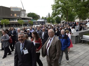 People mill about after the evacuation of the Shaw Centre, Rideau Centre and Westin Ottawa Hotel after a large sinkhole formed on Rideau Street on June 8, 2016.