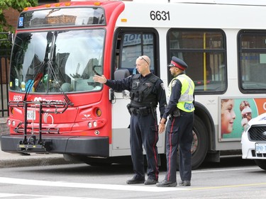 Police officers direct traffic on Waller St. during the afternoon after a sink hole occurred on Rideau St., June 08, 2016.  Photo by Jean Levac 
keyword: sinkhole Rideau Street