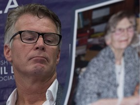 Price Carter, son of Lee Carter, is seen during a news conference June 6, with a picture of his mother, whose assisted dying case is changing Canada's laws.