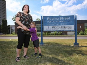 Melanie Good and her son Ryan in front of Regina Street Public School in Ottawa Monday June 20, 2016. Melanie and a group of parents are trying to save the school from being shutdown.