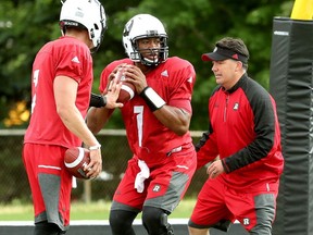 Starting Quarterback Henry Burris, centre, trains with backup QB Trevor Harris, left.