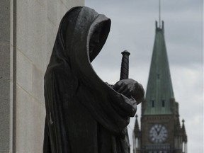 The Peace tower on Parliament Hill is seen behind the justice statue outside the Supreme Court of Canada in Ottawa, Monday June 6, 2016.