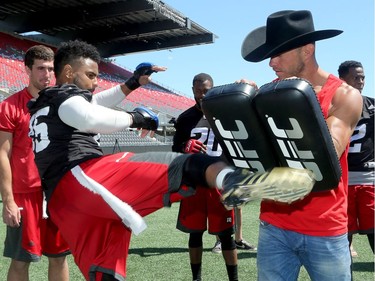 UFC fighter, Donald Cerrone (right) teaches Redblacks linebacker, Damaso Munoz, how to throw a good kick.