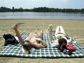 University students Kaara Smith, 21 on right, and Ewa Kozakiewicz, 22, enjoy their day off from studying to take in some rays and do a little reading at Mooney's Bay Beach on a sweltering Monday afternoon.