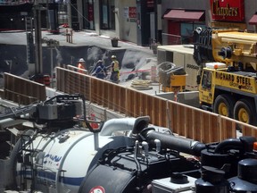 As engineers on Friday ventured into the LRT tunnel far below Rideau Street to assess the damage caused by the massive sinkhole that opened up earlier this week, crews above them continued working around the clock to repair the damage at street level. (Jean Levac/Postmedia)