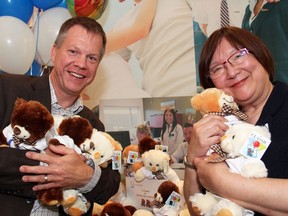 Walter Noble, executive director of the Children's Aid Foundation of Ottawa, with Quota Club of Ottawa president Willy Lee, at the 70th anniversary of the service club in Ottawa, celebrated at Algonquin College's Restaurant International on Monday, June 27, 2016, and marked with its gift of 70 teddy bear for children coming into foster care.