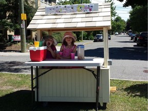 Eliza, 7, and Adela, 5, are seen at the scene of the crime ... their lemonade stand on the median facing Echo drive.