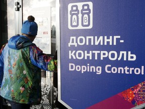 A man walks past a sign reading doping control, at the Laura biathlon and cross-country ski center, at the 2014 Winter Olympics, Friday, Feb. 21, 2014, in Krasnaya Polyana, Russia.