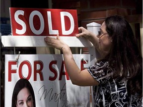 A report by RBC Economics says housing affordability continued to decline in Toronto and Vancouver, while conditions for homebuyers improved in Alberta during the first quarter of the year as lower oil prices caused the real estate market to soften. A real estate agent puts up a "sold" sign in front of a house in Toronto Tuesday, April 20, 2010. THE CANADIAN PRESS/Darren Calabrese