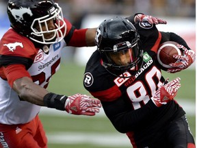 Ottawa Redblacks' Chris Williams (80) runs the ball against Calgary Stampeders' Tommie Campbell (25) during the first half of a CFL football game in Ottawa on Friday, July 8, 2016.