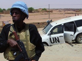 A picture taken on July 14, 2016 shows a soldier of the United Nations mission to Mali MINUSMA standing guard near a UN vehicle after it drove over an explosive device near Kidal, northern Mali.  / AFP PHOTO / SOULEYMANE  AG ANARASOULEYMANE  AG ANARA/AFP/Getty Images