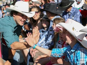 Calgary, Alberta; July 4, 2014 -- Justin Trudeau high fives kids while at the 2014 Stampede Parade in Calgary, on July 4, 2014.  (Photo by Crystal Schick/Calgary Herald) For City, story by TBA. Trax # 00056942A ORG XMIT: POS2014070414443541