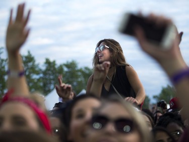 A fan up on shoulders watching Nelly rock the Claridge Homes Stage.