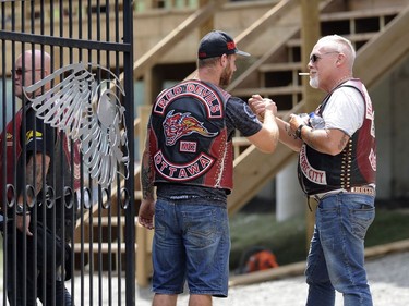 A member of the Hells Angels greets a support club member at the Hells Angels Nomads compound during the group's Canada Run event in Carlsbad Springs, Ont., near Ottawa, on Saturday, July 23, 2016.