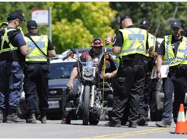 A member of the Hells Angels is stopped at a police roadblock near the Hells Angels Nomads compound before the group's Canada Run event in Carlsbad Springs, Ont., near Ottawa, on Friday, July 22, 2016.