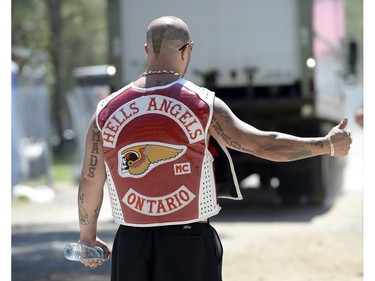 A member of the Hells Angels stands outside the Hells Angels Nomads compound before the group's Canada Run event on Friday, July 22, 2016, in Carlsbad Springs, Ont., near Ottawa.