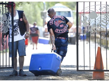 A member of the Red Devils motorcycle club carries a cooler into the the Hells Angels Nomads compound before the group's Canada Run event on Friday, July 22, 2016 in Carlsbad Springs, Ont., near Ottawa.