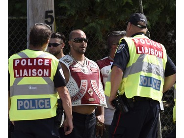 A Police Liaison team speaks with a member of the Hells Angels at the Hells Angels Nomads compound during the group's Canada Run event in Carlsbad Springs, Ont., near Ottawa, on Saturday, July 23, 2016.