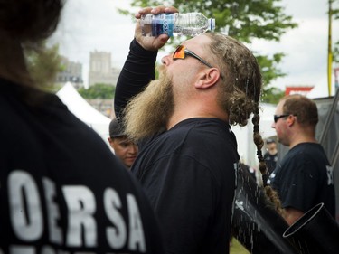 A security guard in the pit at the City Stage cools down by pouring a bottle of water on his head.
