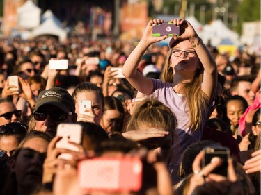 A young girl takes a photo as Alessia Cara performs on the City Stage.