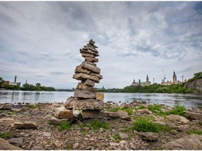 An inukshuk stands at the end of Victoria Island with Parliament Hill in the background overlooking the mighty Ottawa River which will be designated as having heritage status.