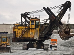 A worker walks beside a mining electric shovel, inside the 2.5 kilometre-wide asbestos mining pit at the Jeffrey Mine Inc. site in the town of Asbestos, Que. The mine has since closed. (THE GAZETTE/Dario Ayala)