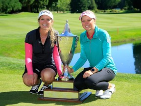 Brooke Henderson, right,  and sister Brittany Henderson,  her caddie, hold the trophy after winning the Cambia Portland Classic held at Columbia Edgewater Country Club on July 3, 2016 in Portland, Oregon.