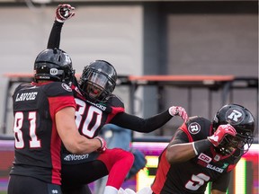 Chris Williams, centre, celebrates his touchdown with Patrick Lavoie in the first quarter of the home opener at TD Place stadium on Friday, July 8, 2016.