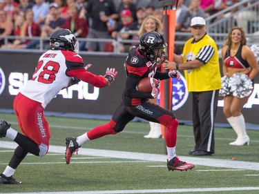 Chris Williams runs for a touchdown with Brandon Smith of Calgary in pursuit in the first quarter.