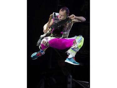 Flea of the Red Hot Chili Peppers jumps while performing on the main stage.