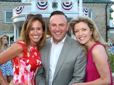 From left, California native Carrie Cuhaci with her good friends Chad Schella and Catherine Clark in front of U.S. ambassador's official residence in Rockcliffe Park for the 4th of July party hosted by the U.S. embassy on Monday, July 4, 2016.