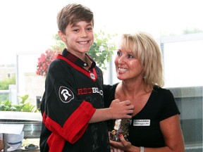 Hearts swelled as Crohn's patient Angus Albinati, 10, handed over his $200-plus in savings to the Michele Hepburn, president of the IBD Foundation, during a fundraising party held at Redblacks co-owner Jeff Hunt's private condo prior to the team's home opener on Friday, July 8, 2016.