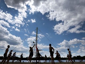 A group of friends play volleyball.